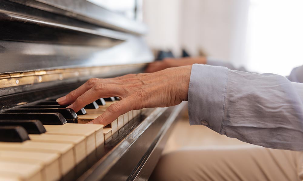 An elderly person playing the piano