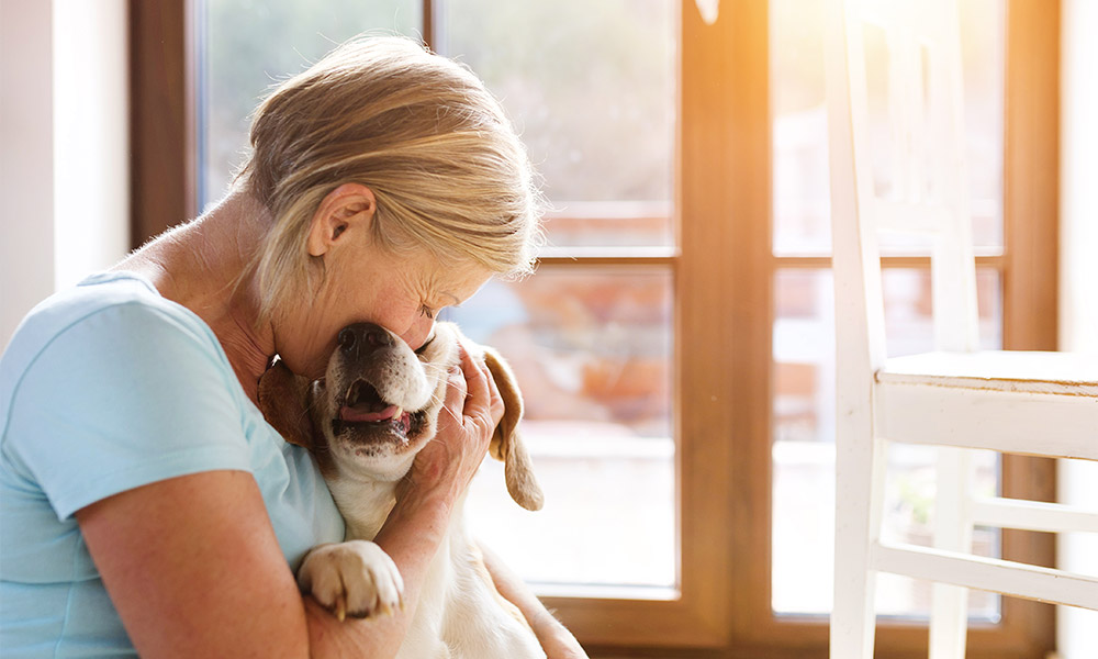 Ederly woman giving her pet a big hug