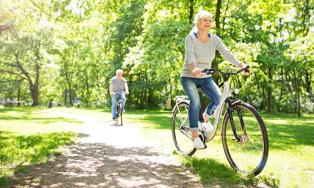 Retired couple celebrating spring by riding their bikes